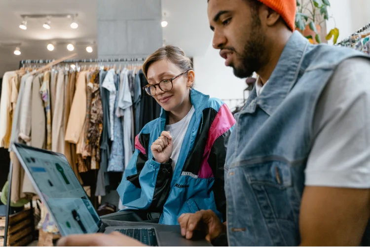Two online sellers managing their shop on a laptop